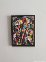 Overall view of framed abstract painting against wall