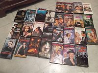 Overview shot of all 26 VHS tapes in the collection, showing the variety of titles including Charlie Chan, Jaws, Cabaret, and others.