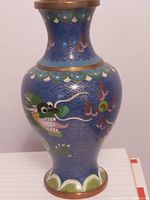 Full height view of the vase showing dragon and cloud patterns with blue enamel and metal rim base