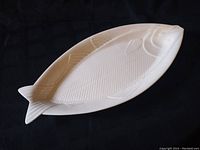 Full view of large white ceramic plate shaped like a fish, showing overall size and design.