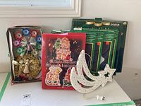 Lot of Christmas decorations including star silhouette, angel decoration, and boxes of lights