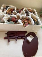 Full set of Christmas nativity figurines in Styrofoam packaging, including wooden base and stands.