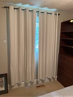 Curtain panels hung on rod covering window, showing full length and fabric texture.