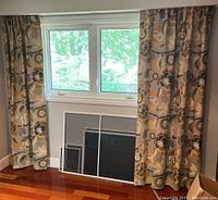 Full view of curtains hanging from metal rod in front of window with hardwood floor below