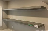 Two floating wall shelves mounted on a wall, showing front and side views of the shelves and details of their dimensions and color.