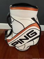 Side view showing the Ping logo and overall white, orange and black vinyl design