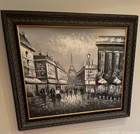 Framed Paris street scene painting with visible signature on canvas, ornate wood and gold frame
