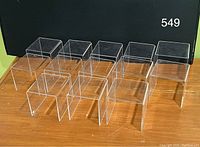Thirteen clear acrylic riser units arranged in rows. Each piece is a U-shaped stand, transparent and made of acrylic, measuring about 4.5 x 4 x 4 inches.