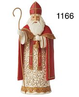 Photo of a 7.2 inch multicolor figurine representing Belgian Santa St. Niklaas. Wearing red bishop-style attire with gold accents, holding a bell and staff.