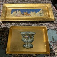 Photo of both decoupage trays, rectangular and square, showing gold finish with central decorative images.