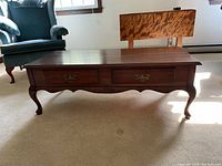 Front side view showing two drawers with brass handles and curved legs on the coffee table.