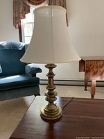 Solid brass Stiffel table lamp photographed in living room environment showing the lamp, base and shade details.