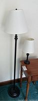 Full view of matching floor and table lamps showing metal bases and white shades