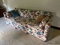 Full view of Ethan Allen floral sofa with throw pillows on carpeted floor.