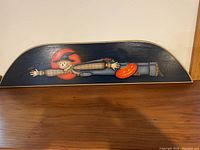 Front view of the hand painted Halloween wooden wall plaque showing the scarecrow figure and pumpkin detail on a dark background.