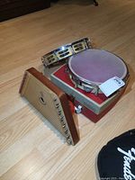 Photo showing two tambourines, the small harp, and part of the record player with a visible tonearm and RCA Victor logo.