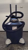 Front view of Shop Vac Quiet Plus 12 gallon wet/dry vacuum with hose and attachments organized around the unit.
