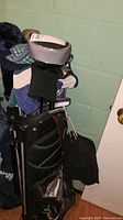 Black golf bag filled with various golf clubs with headcovers