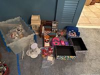 Overview of all items including doll house parts, storage bin with accessories, decorative boxes, stands, toy purse, and other small items arranged on carpet