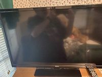 Front view of the 32 inch Seiki TV and remote control resting on a surface.