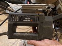 Photo of the Black and Decker jig saw showing the side label, handle, and body of the tool.
