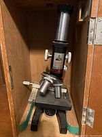 Tower model 6357 microscope showing metal and glass optical components, black base, and adjustment knobs