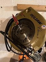 Side view of the Skilsaw Classic corded circular saw showing the blade, red lever clamp, and the housing with Skilsaw branding.