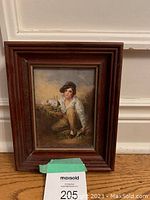 Photo of a small framed vintage picture depicting a child with a white rabbit, in good condition, frame in dark wood.
