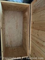 Interior view of the pine wooden storage box showing the bottom and side walls made of wood panels.