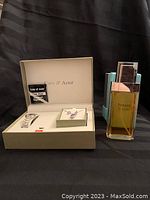 Photo showing Cote d'Azur wristwatch in box with warranty card, amethyst necklace and earrings set in jewelry box, and Tiffany perfume atomizer bottle with packaging.
