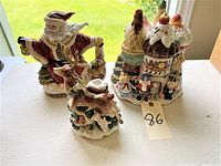 Three Fitz and Floyd ceramic Christmas decorations: a Santa Claus statue, a deer statue, and a Christmas themed cookie jar.