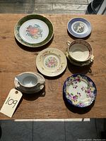 Overview of six small plates and bowls showing various patterns and styles on wooden surface.