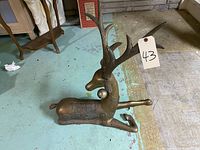 Photo showing a very old brass deer statue lying on the floor, highlighting its 24 inch height and detailed antlers and body texture.
