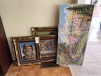 Four knitting artworks grouped together: three framed and one unframed, wrapped in plastic.