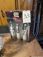 View of the box front showing the set of 3 porcelain snowmen as displayed on packaging