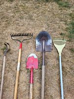 Top-down view of 5 garden tools showing full length and condition on grass ground.