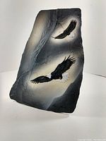 Slate artwork showing two bald eagles in flight on textured slate with gradient gray background.