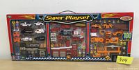 Front view of the new 100 piece Super Playset in original packaging showing the contents including police, fire, and construction vehicles and stations.