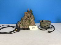 Wide view showing the electric decorative cottage fountain and stone bowl with cords.