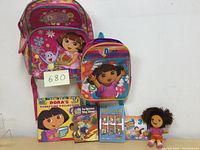 Two Dora backpacks, story book, educational CDs, DVD and a doll