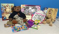Photo showing the entire lot with three teddy bears, activity kits, crayons, sticker album, photo album and other craft supplies on display.