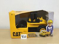 Toy tractor in original box showing front and side with some box damage