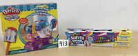 Play-Doh Perfect Pop Maker boxed set and 5-pack soft dough box side by side.