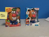 Two Mr. Potato Head sets in original packaging, front view showing one large 60-piece set and one smaller 13-piece PlaySchool Friends set.