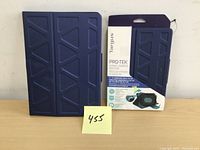 Front view of blue Targus Pro-Tek tablet case with original packaging showing geometric pattern and foldable stand feature.