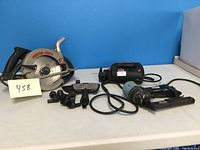 Photo showing all three tools on a white table against a blue background: Porter-Cable skill saw, Jobmate drill, and staple tool.