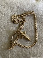 Crucifix pendant and flat link chain laid on fabric