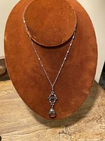 Full view of vintage Victorian style 925 silver choker necklace displayed on brown velvet bust, showing chain and pendant with white drop stone.