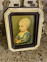 Frontal view of framed tile portrait on green background