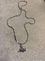 Full view of the silver chain necklace laid flat showing its length and linked design.